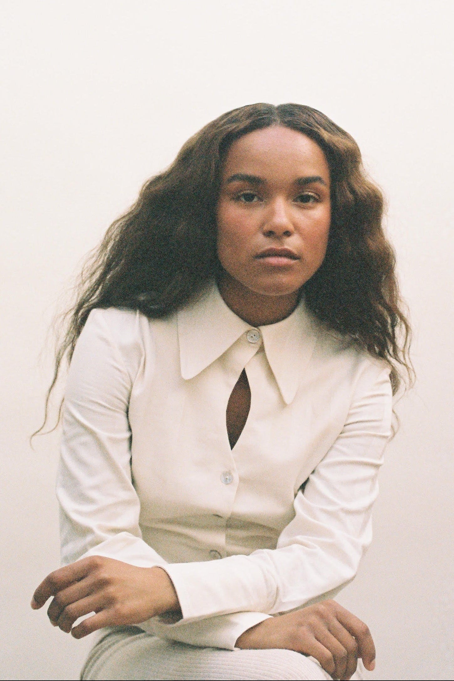 Person wearing a white shirt against a plain background