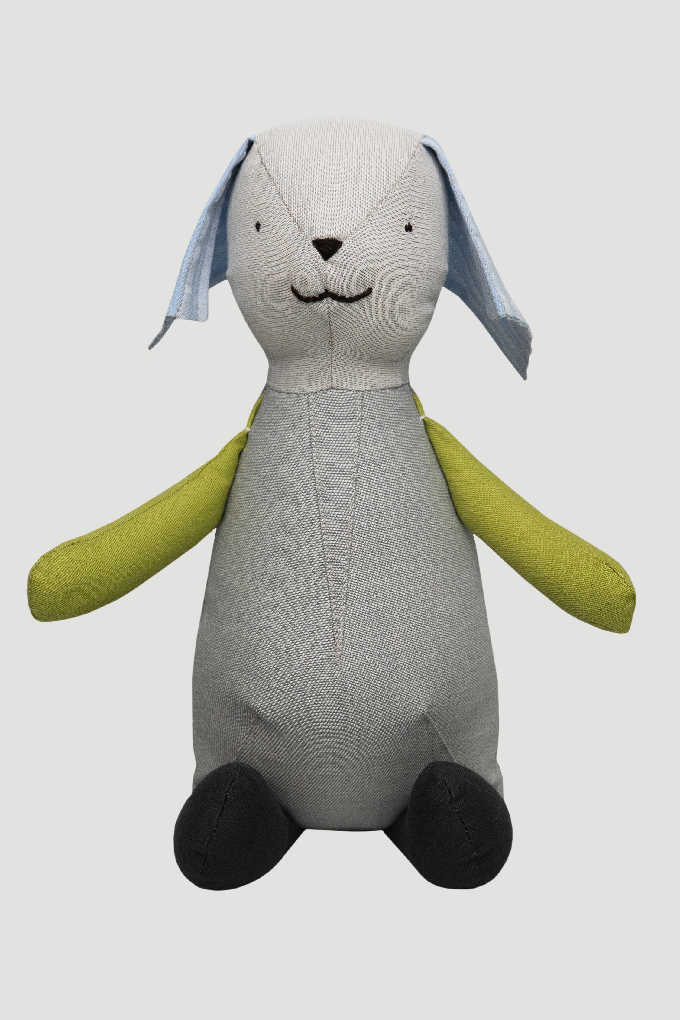 Teddy toy with gray body, green arms, and blue ears on a light gray background