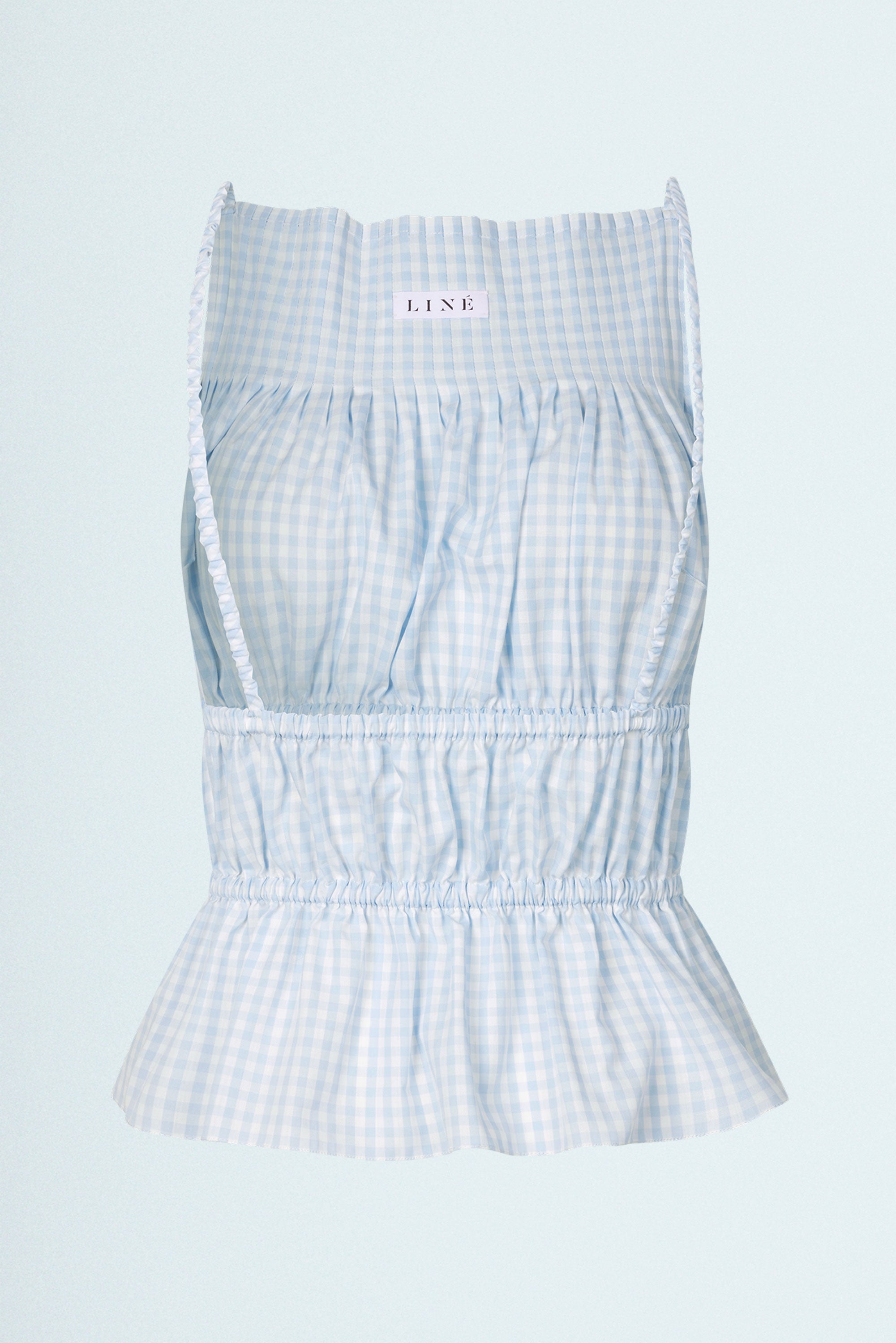 LINÉ Pintuck Top Blue. Pintucks at neckline · Elastic shoulder straps · Elastic casing under the bust and around the waist · Low back · The back hem is slightly elongated and is separated from the front by a small slit in the side seams · Model is 162 cm and wears size 1 · Made-to-order · Produced locally in Denmark · Material: 100 % organic cotton yarn dyed gingham · Collection: Gingham Garments. LINÉ