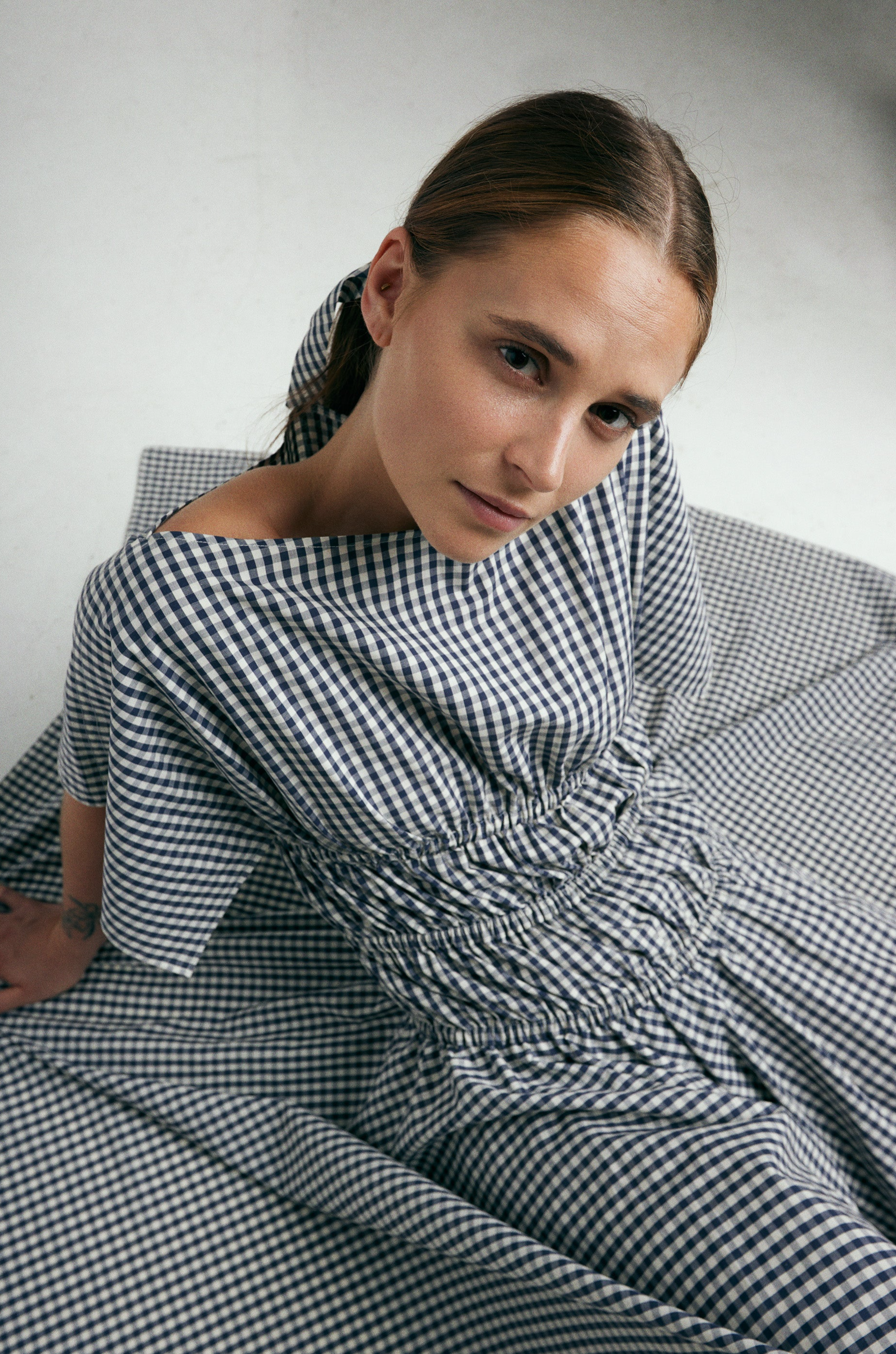 Square Dress Navy. Boat neck · Elastic casing under the bust, around waist and hips · Flared mid length sleeves · The asymmetric skirt is slightly longer in the back · Model is 162 cm and wears size 1 · Made-to-order · Produced locally in Denmark · Material: 100 % organic cotton, yarn dyed gingham · Collection: Gingham Garments. LINÉ