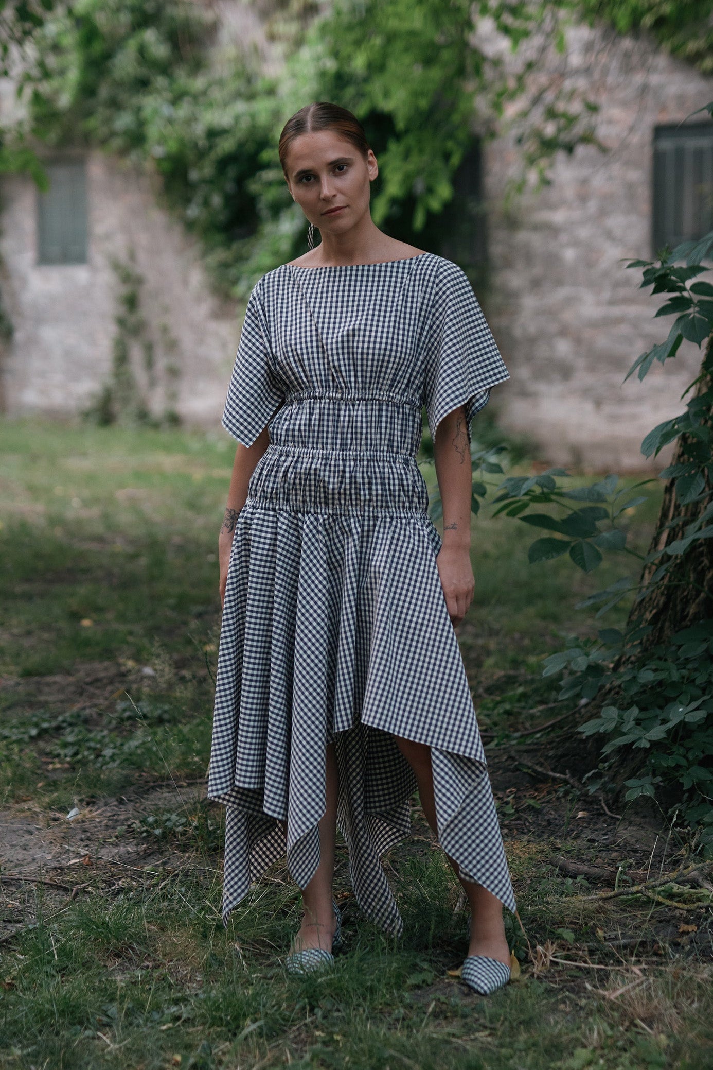 Square Dress Navy. Boat neck · Elastic casing under the bust, around waist and hips · Flared mid length sleeves · The asymmetric skirt is slightly longer in the back · Model is 162 cm and wears size 1 · Made-to-order · Produced locally in Denmark · Material: 100 % organic cotton, yarn dyed gingham · Collection: Gingham Garments. LINÉ