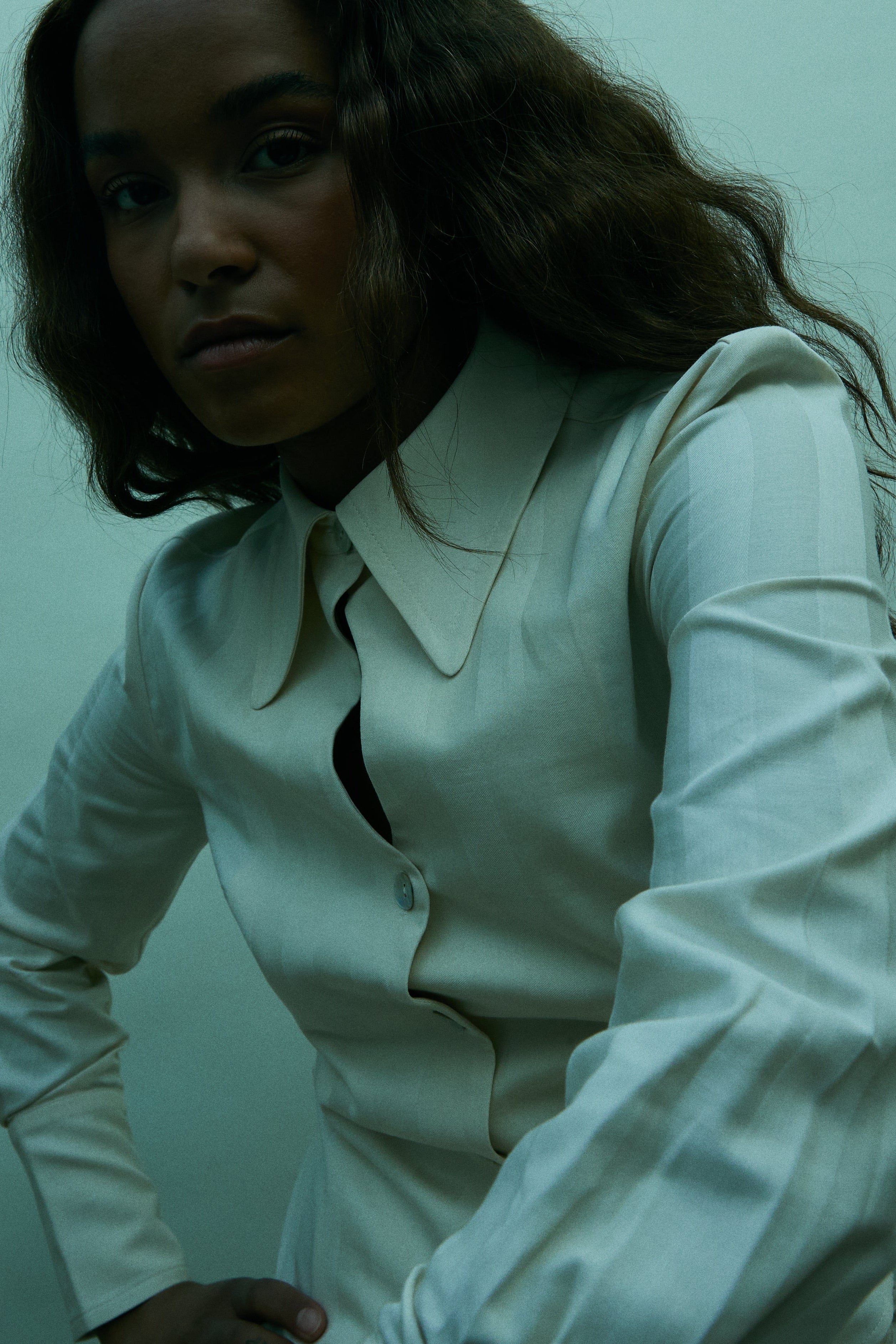 Woman wearing a white shirt against a light green background